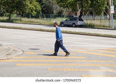 Los Angeles, Ca/USA - April 20, 2020: Homeless Man Not Wearing A Face Mask Properly While Outside Crossing The Street. Homeless In The City Are A Vulnerable Population To COVID-19