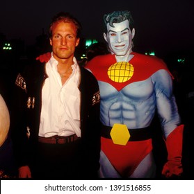 LOS ANGELES - Circa 1991: Actor Woody Harrelson Poses With Costumed Character Captain Planet At An Ecology Fair.