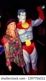 LOS ANGELES - Circa 1991:  Singer Olivia Newton John Meets Costumed Character Captain Planet At An Ecology Fair.