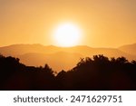 Los Angeles dawn sun rising behind Verdugo Mountain above the San Fernando Valley.  