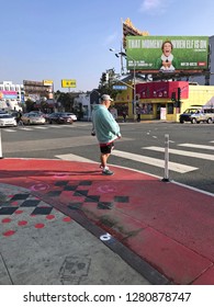 LOS ANGELES, Dec 12th, 2018: A Pedestrian Waits At A Red Painted Curb Extension On Sunset Boulevard In West Hollywood, Part Of The Sunset Experience, A Pilot Project To Improve Pedestrian Safety.