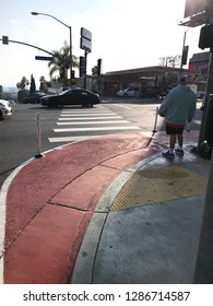 LOS ANGELES, Dec 12th, 2018: A Pedestrian Waits At A Red Painted Curb Extension On Sunset Boulevard In West Hollywood, Part Of The Sunset Experience, A Pilot Project To Improve Pedestrian Safety.