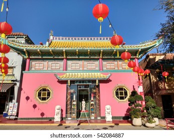 LOS ANGELES, DEC 17TH, 2016: Colorful Red Chinese Paper Lanterns Are Strung Across The Street In Front Of The Traditional Pink Building Of The Realm Store In Old Chinatown In Downtown Los Angeles.