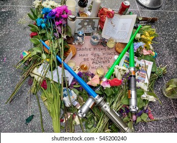 LOS ANGELES, DEC 29TH, 2016: Close up of Carrie Fisher's fan-made star memorial on the Hollywood Walk of Fame, with flowers and light sabers surrounding it in tribute to her Star Wars role.