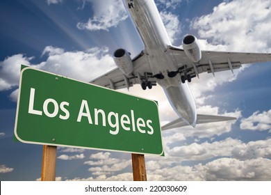 Los Angeles Green Road Sign and Airplane Above with Dramatic Blue Sky and Clouds.