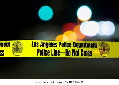 Los Angeles - January 2, 2021: 
Police barricade tape illuminated night exterior with deliberately blurred bakground