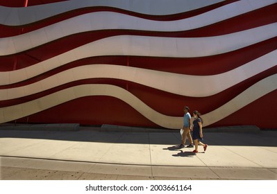 Los Angeles - July 3, 2021: 
A man and woman walk past the Petersen Automotive Museum on Wilshire Blvd. day exterior