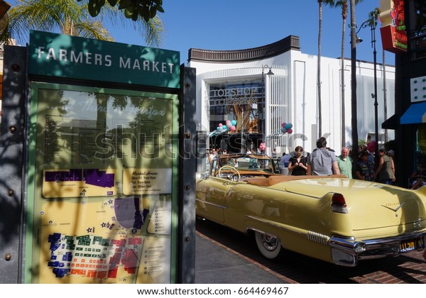 LOS ANGELES, JUN 3RD, 2017: A classic yellow\
car stands next to a Farmers Market sign with map at the famous\
Farmers Market at Third and Fairfax near The Grove shopping mall in\
Hollywood.