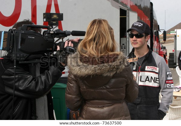LOS ANGELES - MAR 19: \
Extra Interviewing Kevin Jonas at the Toyota Pro/Celebrity Race\
Training Session at Willow Springs Speedway on March 19, 2011 in\
Rosamond, CA