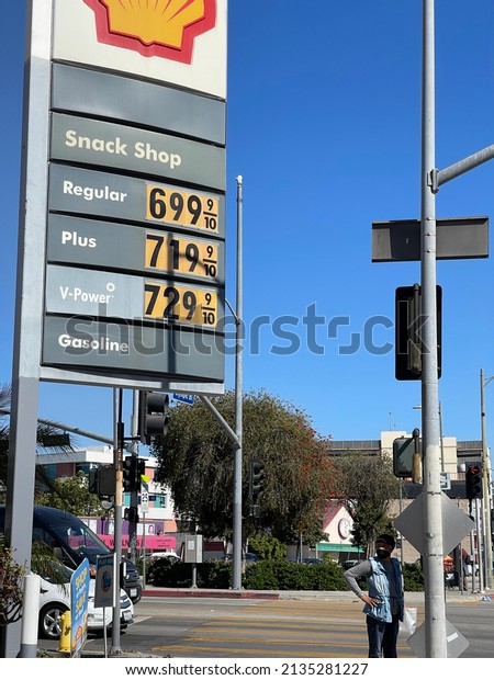 LOS ANGELES, March 11th, 2022: High gas prices.\
Pedestrian next to Shell gas station sign, showing prices of over 7\
dollars a gallon.