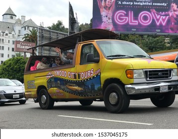 LOS ANGELES, May 21st, 2019: Tourist Waving Out Of A Yellow Sightseeing Tour Bus In Front Of The Chateau Marmont Hotel And A Glow TV Series Billboard On Sunset Boulevard In Los Angeles, California.