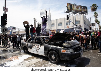 LOS ANGELES - MAY 30, 2020: Unidentified Participants Standing On Burned Police Car During The Protest March Against Police Violence Over Death Of George Floyd.