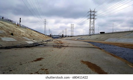 The Los Angeles river with dark sky and with row of high voltage pylons