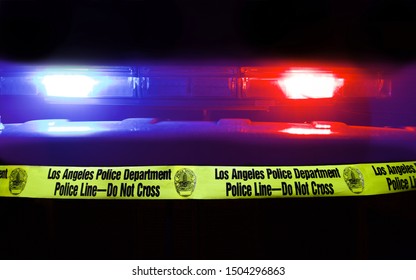 Los Angeles - September 13, 2019: Focus on crime tape with flashing Police car light bar in background