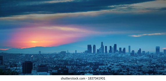Los Angeles skyline at sunrise, panoramic city view from Hollywood Hills.