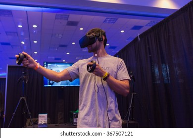 Los Angeles, USA - January 23, 2016: Man tries virtual reality headset and hand controls during VRLA Expo Winter, virtual reality exposition, at the Los Angeles Convention Center.
