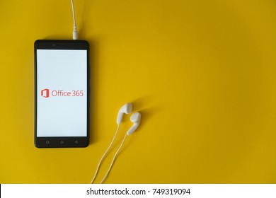 Los Angeles, USA, october 23, 2017: Microsoft office 365 logo on smartphone screen and earphones plugged in on yellow background.