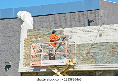 LOS ANGELES/CALIFORNIA - SEPT. 29, 2018: Masonry Worker Applying New Stone Veneer To A Building Facade In Downtown Los Angeles.  Los Angles, California USA