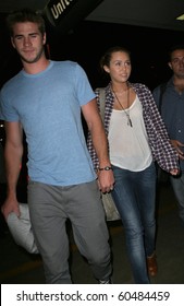 LOS ANGELES-JUNE 14: Singer Miley Cyrus With Boyfriend Liam Hemsworth At LAX. June 14th In Los Angeles, California 2010