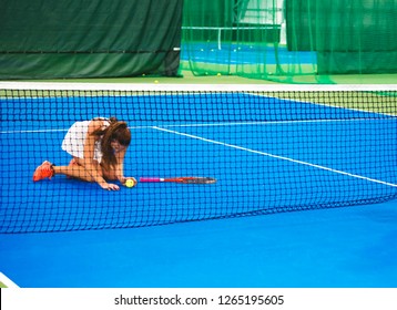 Lose Again. Frustrated Sexy Woman In Sportswear Sitting Near A Tennis Net.The Sportswoman Is Upset