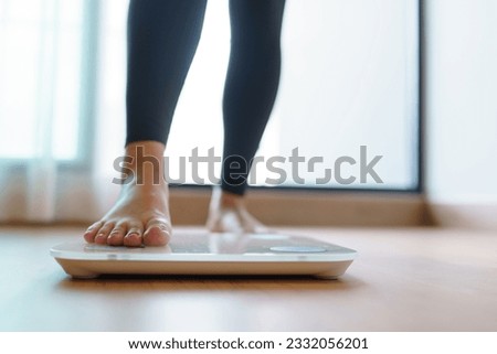 Lose weight. Fat diet and scale feet standing on electronic scales for weight control. Measurement instrument in kilogram for diet
