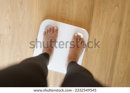 Lose weight. Fat diet and scale feet standing on electronic scales for weight control. Measurement instrument in kilogram for diet