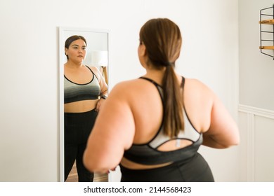 Losing Weight For My Health. Worried Young Woman With Obesity Dieting And Looking Herself In The Mirror