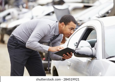 Loss Adjuster Using Digital Tablet In Car Wreck Inspection