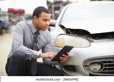 Loss Adjuster Using Digital Tablet In Car Wreck Inspection