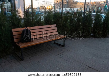 A lost backpack lying on a park bench. A lonely bag in the park. Dangerous object, the threat of terrorism.