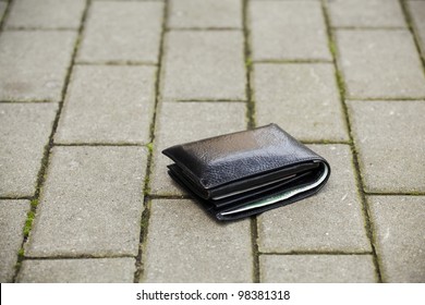 Lost black leather wallet with money lost at sidewalk
