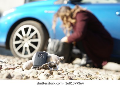 lost car keys lying in the yard in front of the house, selective Focus, shallow depth of field, in the background a woman looking for keys in her purse - Shutterstock ID 1681599364