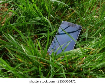 Lost cellphone left in the grass with close up shot selective focus - Powered by Shutterstock