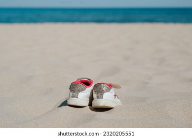 Lost, drowned child, tragedy concept. Children's shoes on an empty beach by the sea. - Powered by Shutterstock