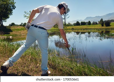 Lost Golf Ball In Water Hazard Golfer Looking In Reeds