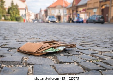 Lost leather wallet with money on the ground on street