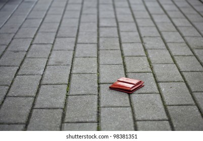Lost leather wallet with money lost at sidewalk