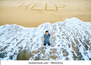 Lost man calls for help on deserted beach of uninhabited island. Inscription HELP on sand of sea or ocean shore. Concept of island life, sos, castaway, shipwreck and survivors on island people. - Shutterstock ID 788323216