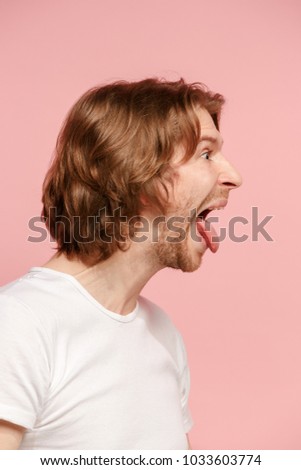I lost my mind. The crazy man with happy expression. Beautiful male half-length portrait isolated on pink studio backgroud. The crazy man. The human emotions, facial expression concept. profile