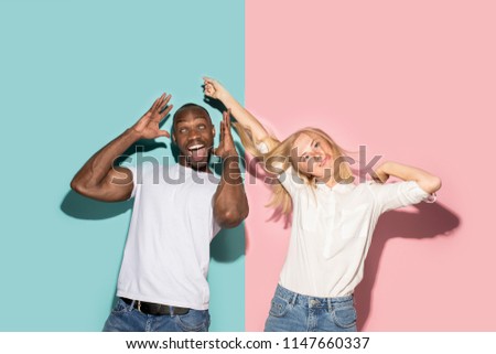 I lost my mind. The eyed couple with weird expression. Beautiful female half-length portrait isolated on trendy pink and blue studio backgroud. The crazy woman and afro man. The human emotions