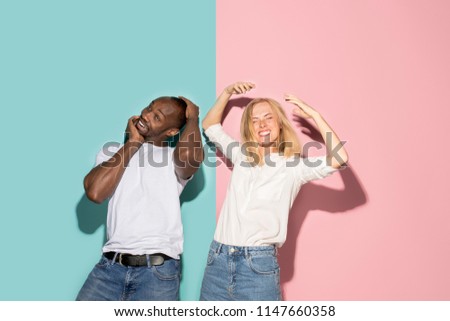 I lost my mind. The eyed couple with weird expression. Beautiful female half-length portrait isolated on trendy pink and blue studio background. The crazy woman and afro man. The human emotions