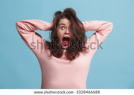 I lost my mind. Stress. The screaming woman with horror expression. Beautiful female half-length portrait isolated on blue studio backgroud. The crazy woman.  April fools day