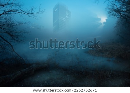  Lost place. an abandoned skyscraper stands over a body of water, blue fog in the foreground. High quality photo