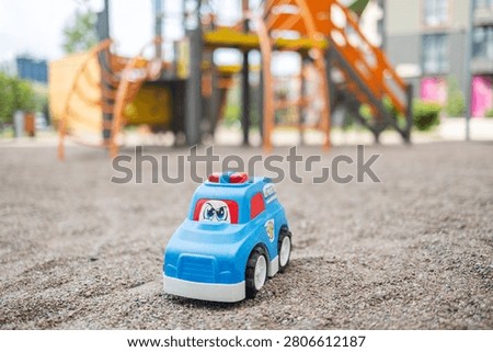 Lost plastic toy lying on playground floor in gloomy day, Lost toy or Loneliness concept.