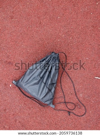 A lost school backpack lying on a park bench. A lonely bag in the park.