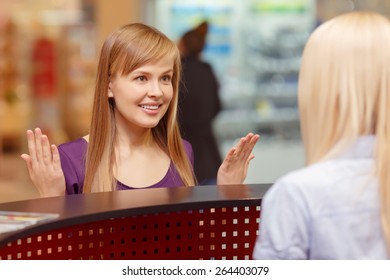 Lost In Shopping. Close-up Of A Young Beautiful Girl Asking For Information At The Shopping Center Reception Desk