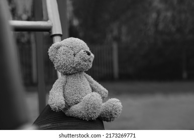 Lost teddy bear sitting on swing at playground in gloomy day, Lonely and sad face brown bear doll sitting alone in the park, lost toy or Loneliness concept, International missing Children day - Shutterstock ID 2173269771