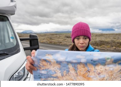 Lost Tourist On Iceland Road Trip Looking For Directions On Travel Map Driving Motorhome Campervan On Europe Adventure Vacation. Asian Funny Face Woman Holding Map.