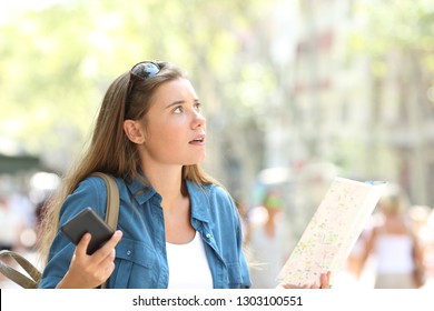 Lost Tourist Trying To Find Location Holding Phone And Paper Map In The Street