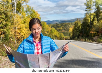 Lost Travel Tourist Woman Searching For Directions On Map On Road Trip In Nature Fall Autumn Outdoors. Funny Asian Girl Making Goofy Face Looking At Map.